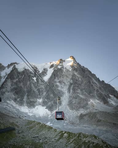 Majestic view of a ski gondola against the rugged peaks of Chamonix, France.