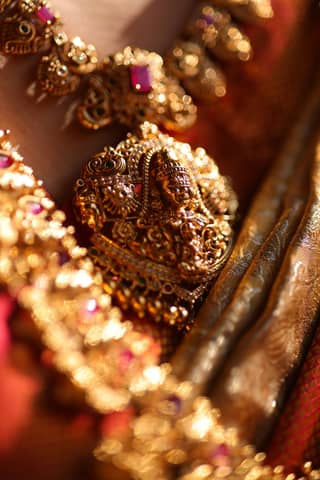 A close up of a woman's gold jewelry