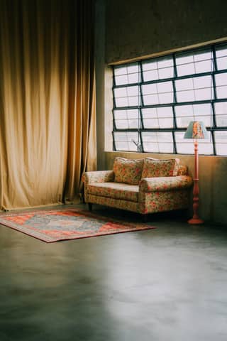 A cozy room with a couch and window.