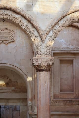Detailed view of a historical stone archway with ornate carvings and classical design elements.