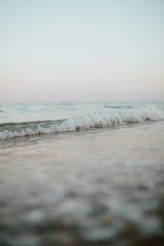 A blurry photo of a wave coming in to the shore