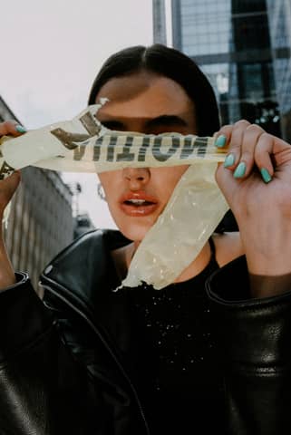 A woman holding up a piece of paper with the word ghetto on it