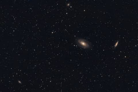 Galaxies and stars shine in the vast night sky.