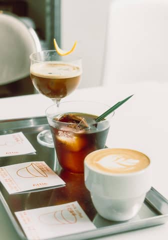 A variety of coffee beverages displayed on a tray in a stylish café setting.