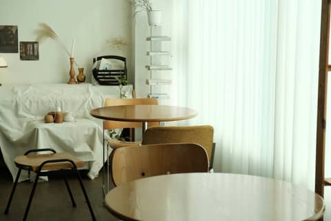 Cozy cafe interior with tables and chairs is shown.
