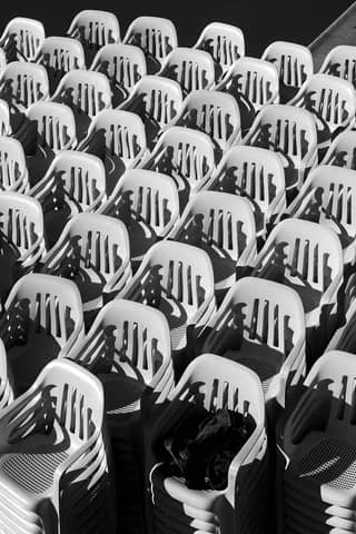 Black and white abstract image of stacked plastic chairs in Mar del Plata, Argentina.