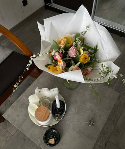 Beautiful bouquet of flowers on a coffee table with candles, creating a cozy indoor ambiance.