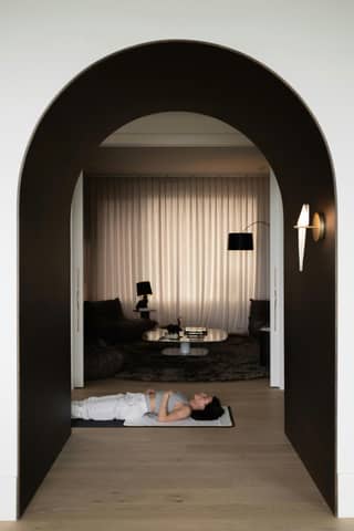 Woman relaxes on mat in an elegant room.