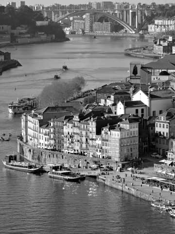 A breathtaking black and white aerial view of Porto, Portugal's riverside and iconic bridge.