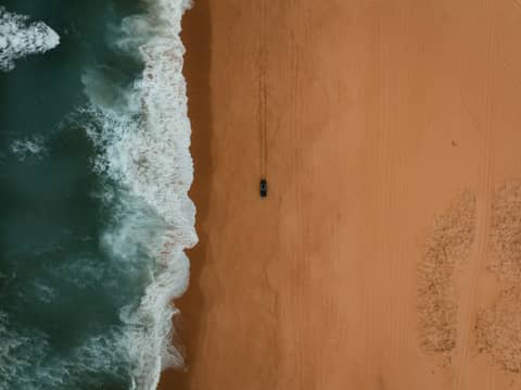 An aerial view of a sandy beach and ocean