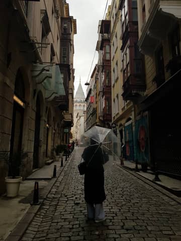 A rainy day street scene in İstanbul with a clear view of the iconic Galata Tower.