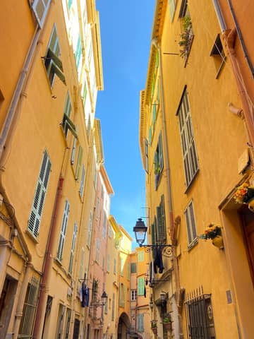 A picturesque alleyway with colorful buildings in a historic European city.