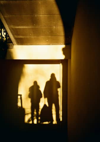 Shadows of two figures cast through a doorway.