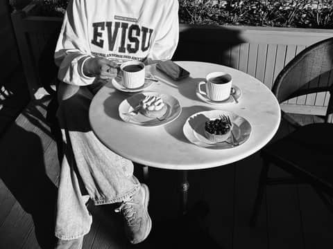 Monochrome cafe scene showing desserts and coffee on a table.