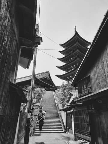 Black and white photograph of a traditional Japanese pagoda and street.
