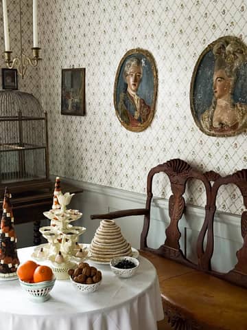 Elegant vintage dining room with decorative treats and antique portraits.