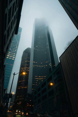 A very tall building towering over a city at night