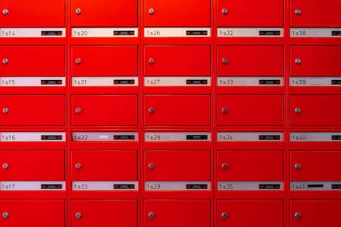Vibrant red mailboxes arranged in a grid pattern, perfect for urban lifestyle visuals.