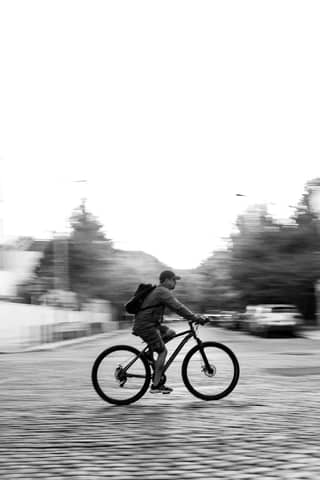 Blurred motion capture of a cyclist in Buenos Aires, showcasing urban life in black and white.