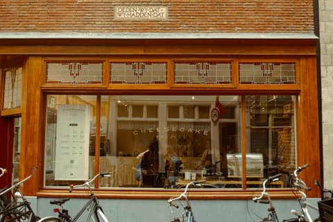 Explore the quaint charm of a cheesecake shop front in Amsterdam's historic streets.