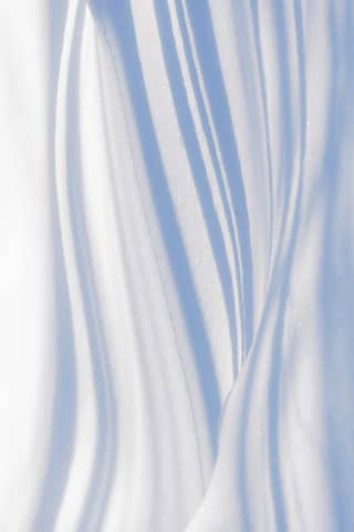 White fabric with shadows creating flowing lines.