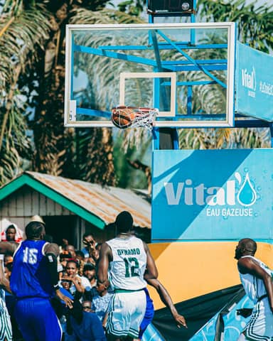 Outdoor basketball game with players in action. Captivating moment as the ball hits the hoop.