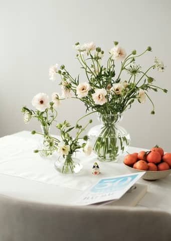 A table topped with a vase filled with white flowers