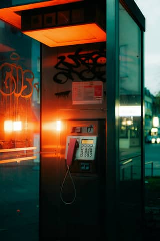 A phone booth with graffiti on the side of it