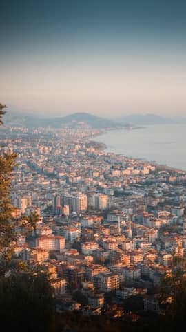 Stunning aerial view of Antalya, Turkey at sunset, featuring a sprawling coastal city landscape.