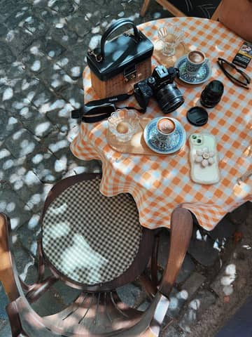 A charming outdoor table setup with coffee, camera, and accessories in Diyarbakır, Türkiye.