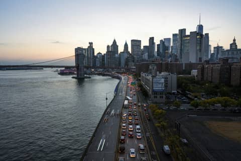 A cityscape with a busy road and river.