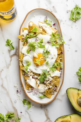 A plate of food with avocado and a bottle of beer