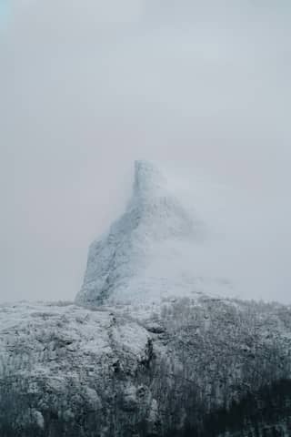 A mountain covered in snow on a cloudy day