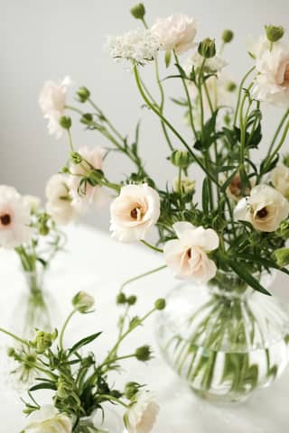 A couple of vases filled with flowers on top of a table