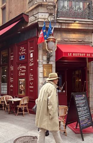 Vintage French bistro with outdoor seating and classic architecture in Lyon, France.