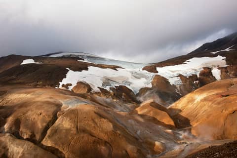 Glacier sits atop an arid, rocky landscape.