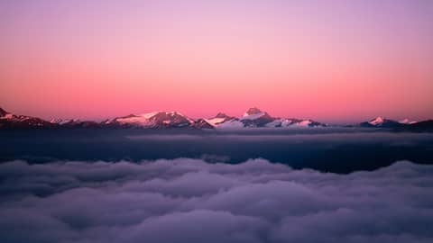 A view of a mountain range from above the clouds