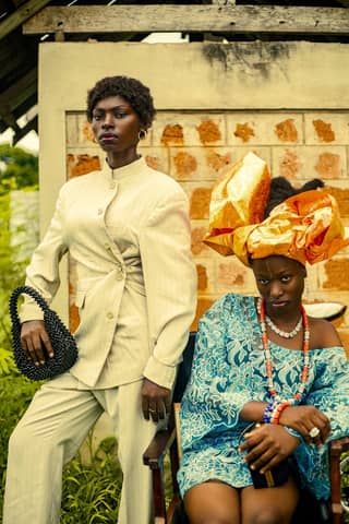 Stylish portrait of two adults in vibrant traditional African attire outdoors.