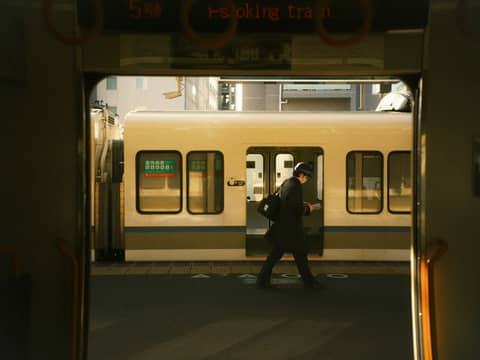 A person walks through a train doorway.