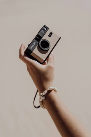 A person holding a camera up in the air
