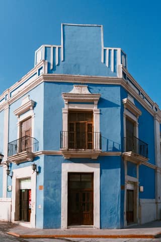 Vibrant blue colonial building in San Francisco de Campeche under clear sky, showcasing beautiful architecture.