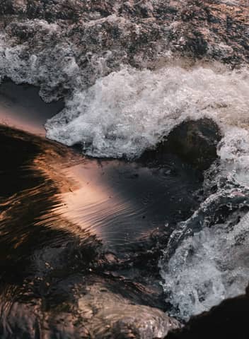 Water flows vigorously over a dark surface.