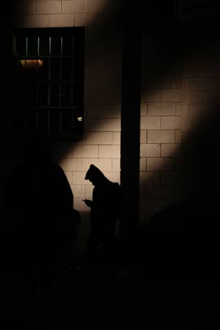 A person sitting on a bench in the dark