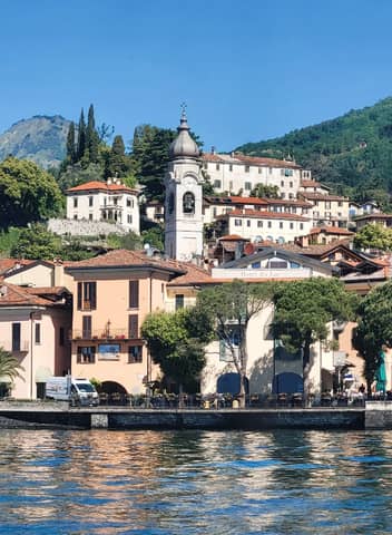 Charming view of Bellano, Italy by Lake Como, showcasing colorful houses and iconic bell tower.
