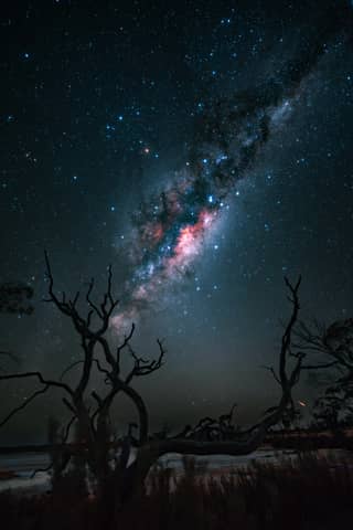 The milky way stretches across the night sky.