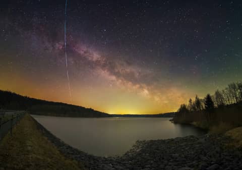 Milky way galaxy and shooting star over the lake.