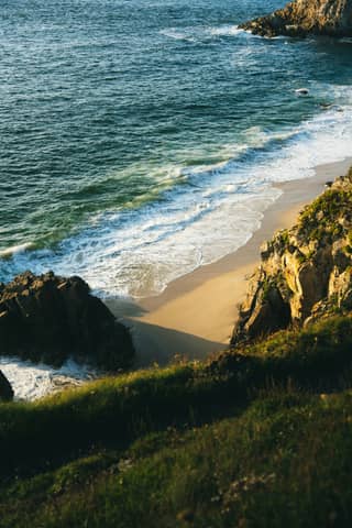 Waves gently crash upon a sandy beach.