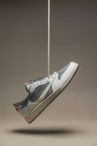 A sneaker is suspended in the air.