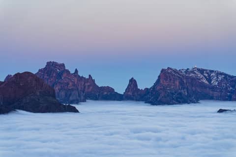 A view of a mountain range from above the clouds