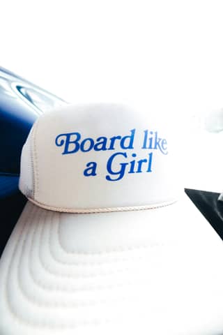 A hat says: "board like a girl".